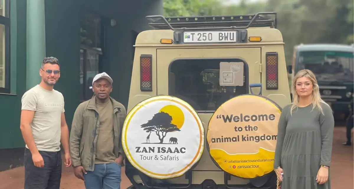 The Zanisaac Tours and Safari team with guests beside a safari vehicle